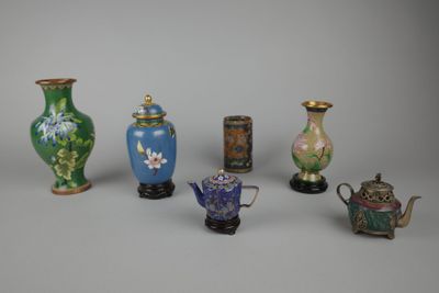 Plusieurs vases et théières sont alignés sur une surface grise