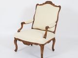 a white chair with a beige upholstered back and arms