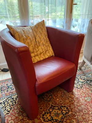 un fauteuil rouge avec un coussin jaune dans un salon