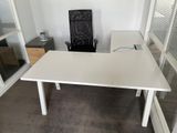 un bureau blanc avec une chaise noire dans un coin