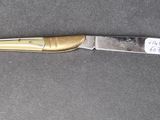 a knife that is laying on a table with a tag on it