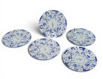 quatre assiettes bleues et blanches ornées de motifs sur fond blanc