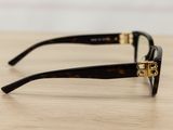 chanel tortoise sunglasses with gold accents on a wooden surface