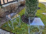 two chairs and a table on the grass in front of a building