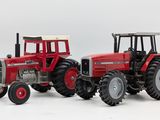 two toy tractors that are sitting side by side on a white surface