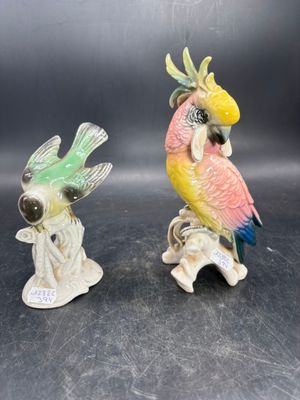 two figurines of parrots sitting on top of each other