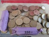 un récipient en plastique rempli d'une multitude de pièces de monnaie et un sac violet