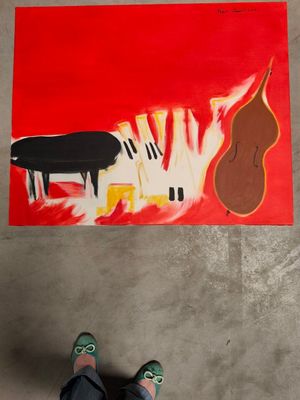 une personne debout devant un tableau représentant un piano et une contrebasse