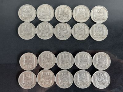 Plusieurs pièces d'argent sont disposées en rangées sur une surface noire