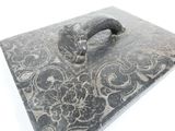 a black and white picture of a square stone with a handle