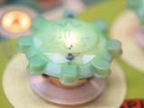 a close up of a pinball machine with a green flower on it