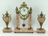 une horloge et trois vases posés sur une table