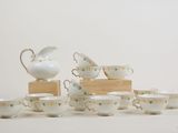 a lot of cups and saucers sitting on a table