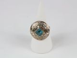 a close up of a ring with a blue stone in it