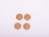 un gros plan sur quatre pièces de un penny posées sur une surface blanche