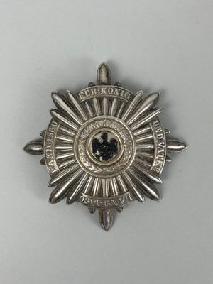 un gros plan d'un insigne posé sur une surface blanche, sur fond blanc