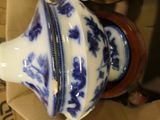 a blue and white vase sitting on top of a cardboard box