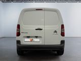 the back of a white van parked in a large room