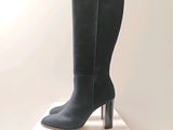 the boots are on a white pedestal with a clock in the background