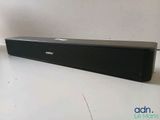 a black speaker sitting on top of a table next to a remote