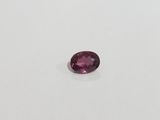 a pink tourmaline gems on a white surface