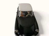 a black toy car with two people in the back seat