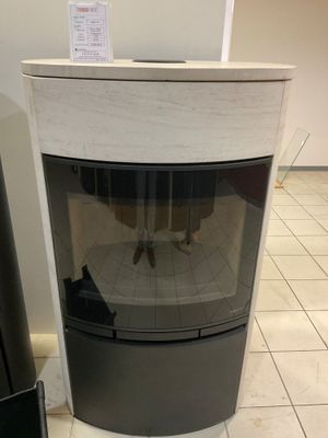 un chat noir et blanc assis devant une cheminée