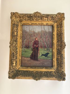 un tableau représentant une femme avec un chien, accroché au mur