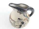 a black and white vase with a picture of a man and a woman on it