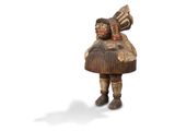 une vieille figurine en bois représentant un homme avec un chapeau sur la tête