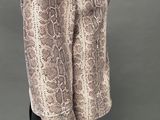 a mannequin wearing a snake skin jacket and black pants