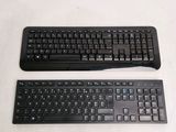 two keyboards sitting next to each other on a white surface