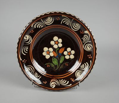assiette marron et blanche ornée de fleurs sur un fond gris