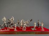 silver figurines of knights and horses on a red surface