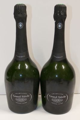 two bottles of champagne sitting on top of a white table