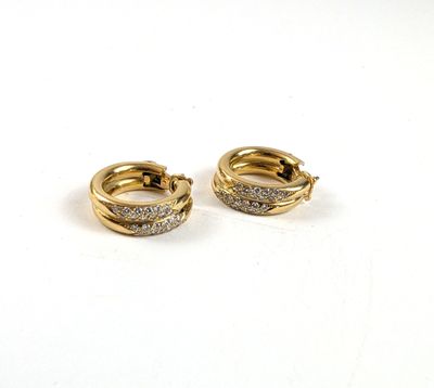 une paire de boucles d'oreilles créoles en diamant sur fond blanc