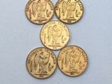 cinq types différents de pièces d'or sur un fond blanc