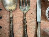 a lot of silver spoons and forks on a table