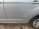 a car that has been dented and is parked on the side of the road