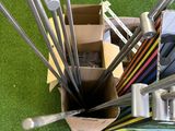 a box of golf clubs and a box of pencils on the grass