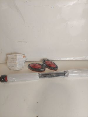une baignoire blanche avec une poignée rouge et une brosse à dents noire et blanche