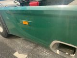 a close up of a green truck with a yellow tag on it