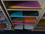 a wooden shelf with many different colored papers on it