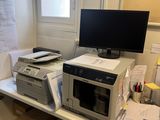 un micro-ondes et un ordinateur posés sur un bureau dans une petite pièce