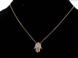 a gold necklace with a hamsa hand pendant on a mannequin neck