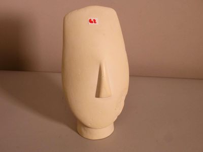a white vase that has a red sticker on it