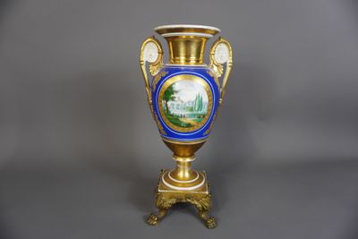 un vase bleu et doré sur lequel est représenté un château