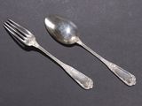 two spoons and a fork sitting on a table