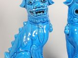 pair of blue foo foo dogs sitting on pedestals on a white background