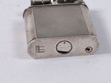 a silver lighter that is sitting on a white surface
